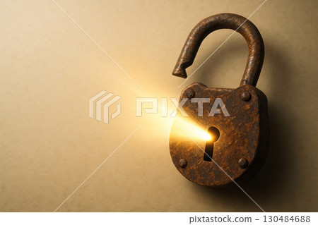 An old rusty lock with light coming out of the keyhole. Space for text. 130484688