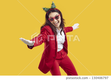 Cheerful funny woman has fun, rejoices and dances during celebration of New Year holidays. 130486797