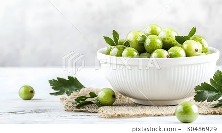 fresh green gooseberries in white bowl 130486929