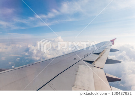 View from the airplane window at a beautiful cloudy sky and the airplane wing 130487921