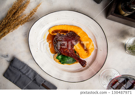 Roasted duck leg with puree on restaurant plate 130487971