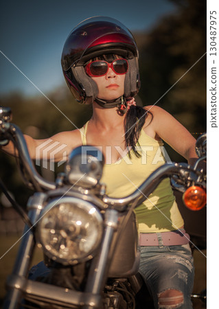 Biker woman sitting by her motorcycle... Biker woman sitting by her motorcycle... 130487975