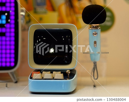 Retro microphone and screen display in modern retail space. Technology, communication, and entertainment in lifestyle and consumer culture. 130488004
