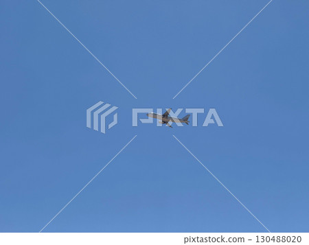 Airplane flying in clear blue sky at high altitude with visible red tailfin. Aviation, transportation, speed, and global connectivity through air travel. Airplane flying in clear blue sky at high altitude with visible red tailfin. Aviation, transportation, speed, and global connectivity through air travel. 130488020