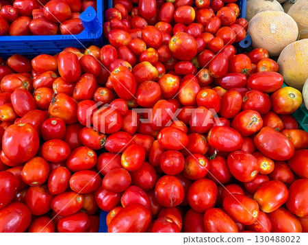 Large red tomatoes with irregular shapes on market stall. Agriculture, farming, and seasonal vegetable harvest with healthy nutrition lifestyle. Large red tomatoes with irregular shapes on market stall. Agriculture, farming, and seasonal vegetable harvest with healthy nutrition lifestyle. 130488022