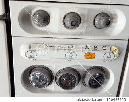 Closeup of airplane cabin panel with air vents and light controls. Passenger service and aviation engineering. 130488233
