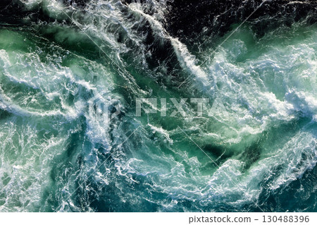 Blue waves of water of the river and the sea meet each other during high tide and low tide. Blue waves of water of the river and the sea meet each other during high tide and low tide. 130488396