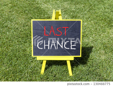 Last chance symbol. Concept word Last chance on beautiful black blackboard. Beautiful green grass lawn background. Black blackboard. Business last chance concept. Copy space. Last chance symbol. Concept word Last chance on beautiful black blackboard. Beautiful green grass lawn background. Black blackboard. Business last chance concept. Copy space. 130488775