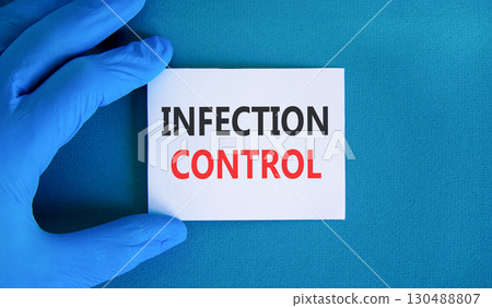 Infection control symbol. Concept words Infection control on beautiful white card. Doctor's hand in blue medical glove. Beautiful blue background. Medical healthy lifestyle infection control concept. Infection control symbol. Concept words Infection control on beautiful white card. Doctor's hand in blue medical glove. Beautiful blue background. Medical healthy lifestyle infection control concept. 130488807