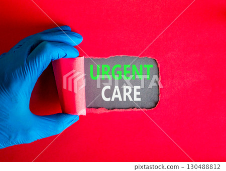 Urgent care symbol. Concept words Urgent care on beautiful grey paper. Doctor hand in blue medical glove. Beautiful red background. Medical healthy lifestyle urgent care concept. 130488812