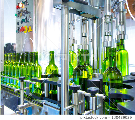 white wine in bottling machine at winery 130489029