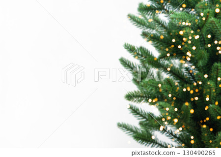 Green Christmas tree and golden glitter confetti and sparkles of lights blur bokeh on a gray background with space for text, promotions, and discounts. Merry Christmas and Happy New Year. Green Christmas tree and golden glitter confetti and sparkles of lights blur bokeh on a gray background with space for text, promotions, and discounts. Merry Christmas and Happy New Year. 130490265
