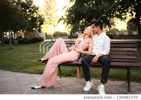 Romantic moment between a couple in a serene park at sunset 130491370