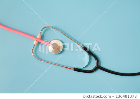 Pink stethoscope in black stethoscope on background. Pink stethoscope in black stethoscope on background. 130491378