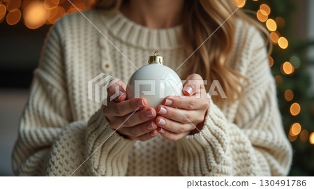 woman's hand holding a Christmas ornament 130491786