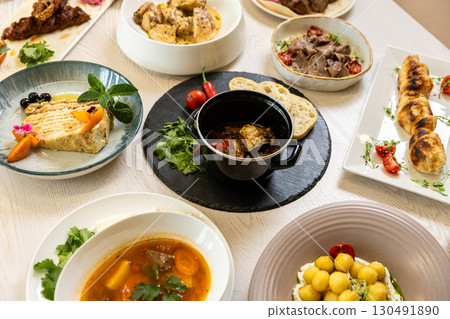 Traditional Middle Eastern dishes served on a white table in restaurant interior 130491890
