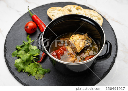 Traditional Georgian khashlama stew with beef, vegetables, herbs and bread on slate plate Traditional Georgian khashlama stew with beef, vegetables, herbs and bread on slate plate 130491917