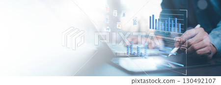 Businessman using computer for development and Analytics Data technology management System for report marketing strategy planning. graph analysis and information on a futuristic virtual screen. 130492107