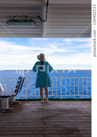 A woman looking out at the sea on the ferry deck 130492533
