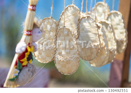 Birch bark souvenir sandals hang on a rope. 130492551