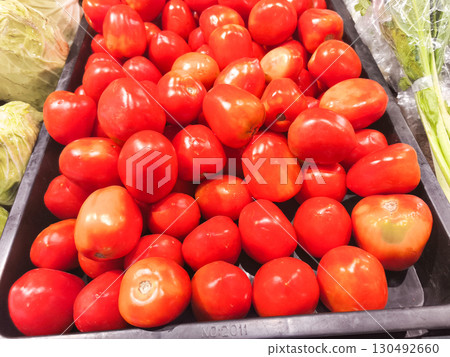 Generous pile of ripe red tomatoes, a fresh and healthy harvest from a local market. Vibrant colors and textures for a food, nutrition, or farm-to-table theme. 130492660