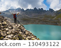 Female hiker with backpack enjoying epic view of Wildsee lake on Pizol mountain range in Switzerland. Travel sport wanderlust concept. 130493122