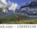 Sporty woman standing in front of snow mountains and enjoying view of Switzerland nature. Wanderlust, sport, beauty in nature. 130493148