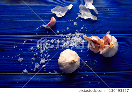 Garlic and salt spread on a blue wooden table 130493357