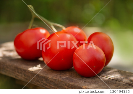 Red round tomatoes. Many red tomatoes on wooden table.Healthy organic red tomatoes on a wooden background. Red round tomatoes. Many red tomatoes on wooden table.Healthy organic red tomatoes on a wooden background. 130494525