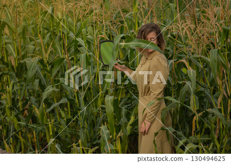 Young happy smiling woman in a green corn field in summer Young happy smiling woman in a green corn field in summer 130494625
