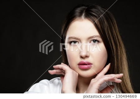 Beautiful girl model with pink sensual lips on a black background. Beautiful girl model with pink sensual lips on a black background. 130494669