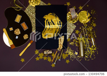 Applying gold paint and gold foil to a work of art. Gilding accessories in golden color for master craftsman. 130494706