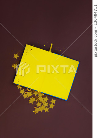 Notepad with yellow paper and gold stars and sequins for creativity. Notebook yellow sketchbook mockup Notepad with yellow paper and gold stars and sequins for creativity. Notebook yellow sketchbook mockup 130494711