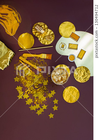 Gold party decoration. Holiday golden glow background.Gold stationery and creative supplies for holiday decor. 130494712