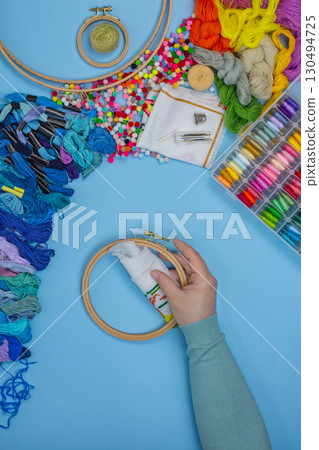 Female hands holding embroidery hoop. Female hand holding wood embroidery frame. 130494725