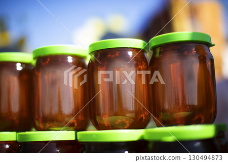 Glass jars filled with honey. Honey trade fair. Glass jars filled with honey. Honey trade fair. 130494873