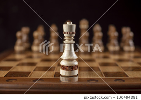 Chess on a dark background. A puzzle game with tricky combinations that requires planning and thinking. 130494881