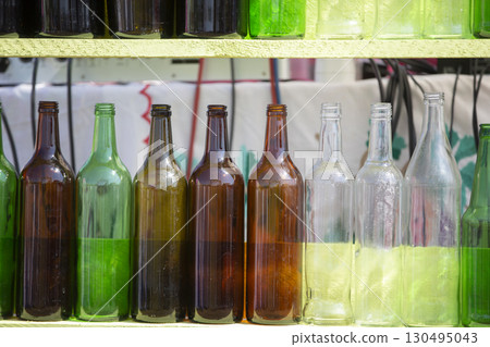 Vintage glass multi-colored bottles are in a row. Vintage glass multi-colored bottles are in a row. 130495043