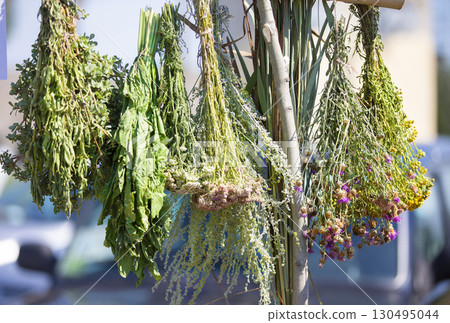 Brooms made of dry medicinal herbs hang in the air. 130495044