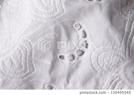 White cotton fabric background with embroidery. A piece of lace fabric. 130495048