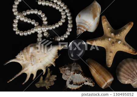 Beautiful seashells with white pearls on a black background. Beautiful seashells with white pearls on a black background. 130495052