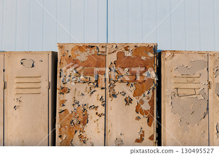 Row of rusty metal lockers with peeling paint 130495527