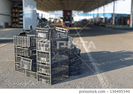 Stack of empty black plastic crates at market 130495540