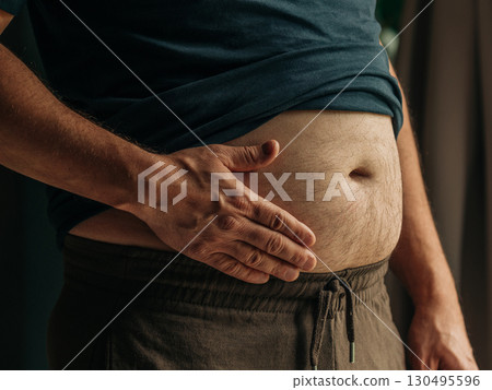 Middle-Aged Man Holding Stomach Close-Up 130495596