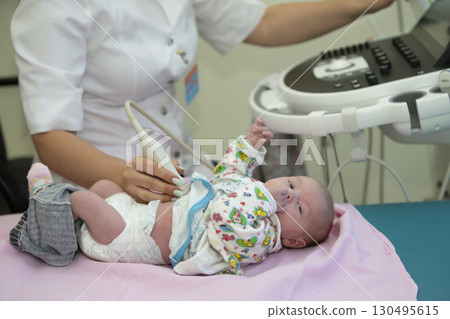 The doctor makes an ultrasound scan for a newborn baby.Medical exam of a baby by ultrasound equipment The doctor makes an ultrasound scan for a newborn baby.Medical exam of a baby by ultrasound equipment 130495615