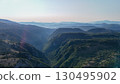 Breathtaking valley landscapes under a serene sky at dawn near the mountains showcasing nature's tranquility and beauty 130495902