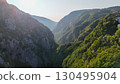 Breathtaking valley vista showcasing lush greenery and majestic mountains at golden hour near a serene village 130495904