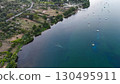 Tranquil riverside retreat showcases boats floating gently on serene waters at sunset near a picturesque village 130495911