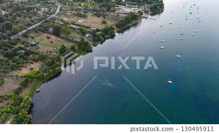 Tranquil riverside retreat showcases boats floating gently on serene waters at sunset near a picturesque village Tranquil riverside retreat showcases boats floating gently on serene waters at sunset near a picturesque village 130495911