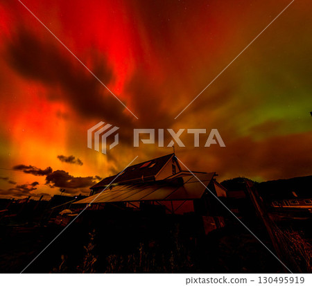 The Aurora Borealis, the northern lights, showing up above bungalow in County Donegal, Ireland 130495919